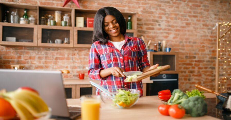 Black woman cooking at home to save money