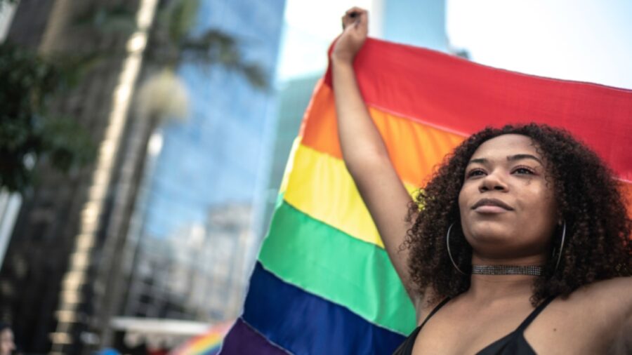 Black woman waving rainbow flag during pride parade